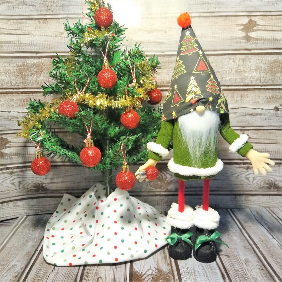 standing gnome decorating a Christmas tree